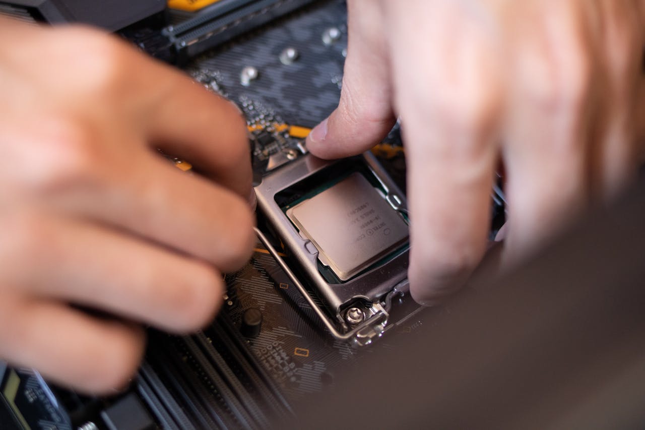 about-02 Detailed view of hands installing a CPU onto a motherboard inside a computer setup.