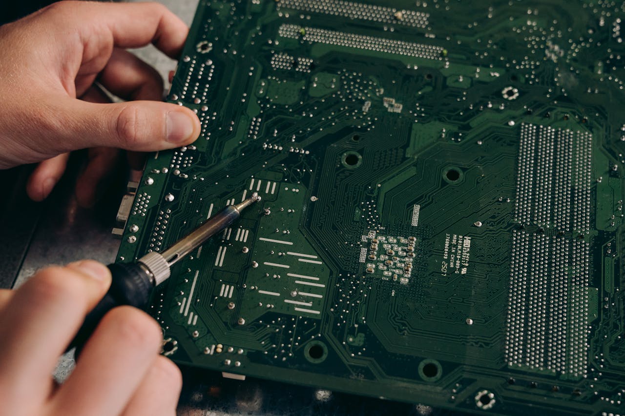 process-img Hands soldering a motherboard with precision demonstrating electronics repair skills.